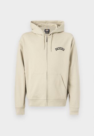 Beež värviga lukuga dressipluus ees taskute, nööridega kapuutsi ja vasakul rinnal "Dickies" logo.