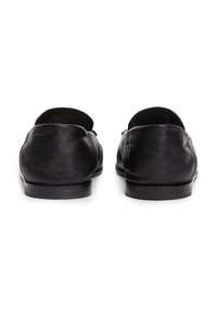 Sorte skinn loafers med en jevn overflate, avrundede bakker og lavprofilerte gummisåler. Ingen synlig maskinvare eller mønstre.