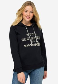 Sudadera negra con cordón, que presenta gráficos en texto blanco. Hecha de material suave, tiene un corte relajado y puños acanalados.