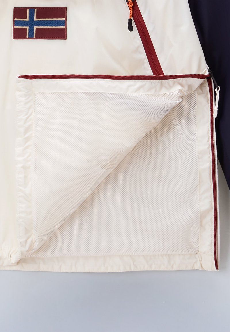 Chaqueta con una concha blanca, acentos en color burdeos y un parche de la bandera islandesa. Incluye un bolsillo con cremallera forrado de malla.