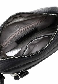Interno di una borsa in pelle nera con una tasca con zip, rivestimento in tessuto grigio, scomparti per l'organizzazione e un motivo logo sottile.