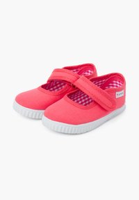 Scarpe di tela rosa brillante con suola di gomma bianca, dotate di una fascia adesiva e di una foderatura interna a scacchi.