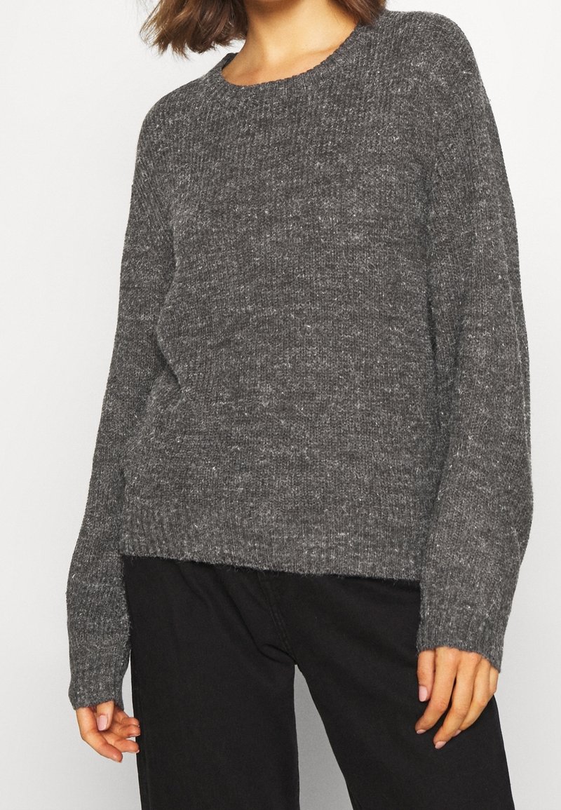 Maglione grigio a maglia con scollo rotondo, maniche lunghe e vestibilità comoda. La texture è morbida con un motivo leggermente spesso.