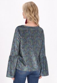 Blůza s dlouhým rukávem z vzorované tkaniny s paisley designem v zelených, modrých a hnědých tónech; rozšířené rukávy; hladká textura.