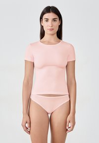 Różowa bluzka z krótkim rękawem i pasującym bikini, wykonana z gładkiego, elastycznego materiału. Prosty design z okrągłym dekoltem. Brak widocznych elementów metalowych lub wzorów.