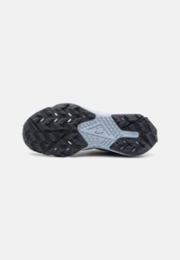 Semelle extérieure d'une chaussure de running Nike noire et grise avec un motif de grip texturé et le marquage « Nike React » au centre de la semelle.