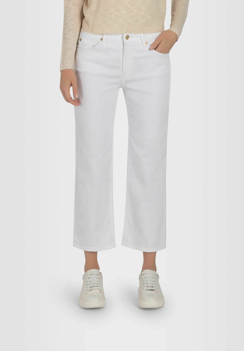 White denim culottes with a straight cut, featuring a mid-rise waist, front pockets, and brass button hardware. Paired with white sneakers.