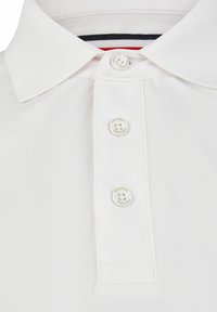 Witte polo met een klassieke kraagontwerp, een drieknoopsluiting en een gestructureerde stof met subtiele stiksels.