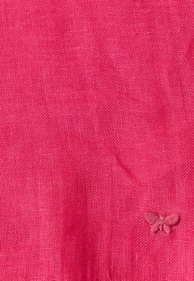 Φωτεινό ροζ υφαντό ύφασμα με μικρή κεντημένη πεταλούδα στην κάτω δεξιά γωνία.