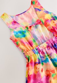 Vestito senza maniche colorato realizzato in tessuto leggero e fluente. Presenta motivi floreali in rosa, giallo, verde e blu con una vita arricciata.