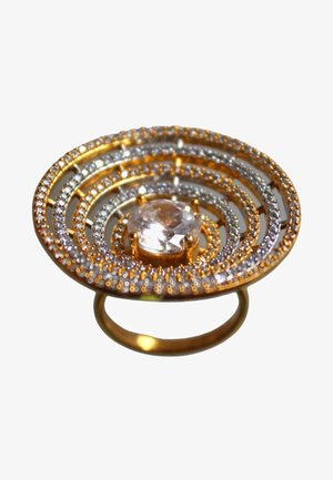 Gouden ring met concentrische cirkelpatronen, versierd met kleine heldere stenen en een grote centrale heldere edelsteen.