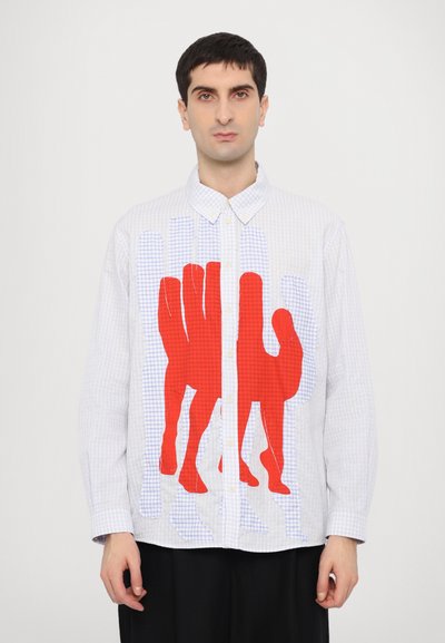 Camisa de botones con un patrón a cuadros en azul claro y una gran gráfica de mano roja en la parte frontal. Presenta un collar pointed y botones blancos.