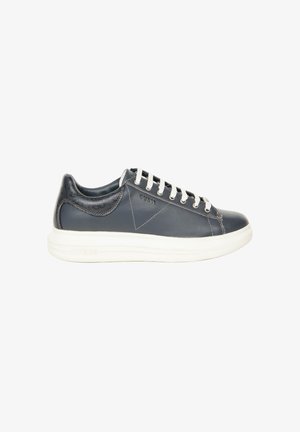 Baskets basses en cuir noir pour homme avec lacets blancs et semelle blanche épaisse, marquées "Guess" sur le côté et le talon.