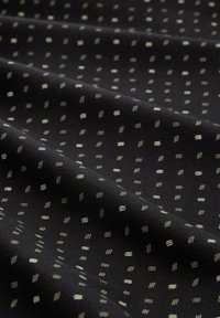 Cotton fabric in black with a repeating pattern of small white wavy lines and dots, showcasing a smooth texture and subtle visual detail.