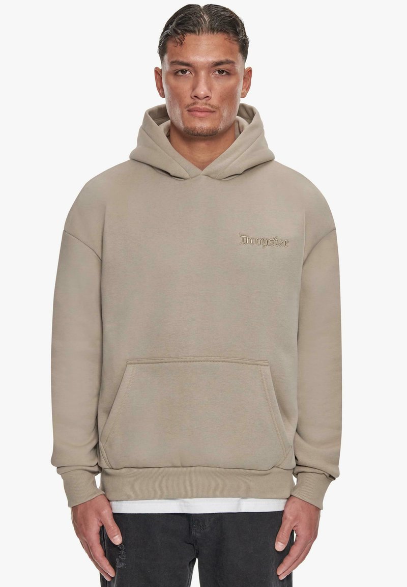 Beige hoodie with a front pouch pocket, adjustable drawstring hood, and embroidered "Dropsie" logo on the chest. Soft texture and relaxed fit.