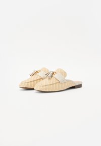 Sandali slide beige intrecciati con un motivo testurizzato, una singola fascia beige con una fibbia dorata e una suola marrone bassa.