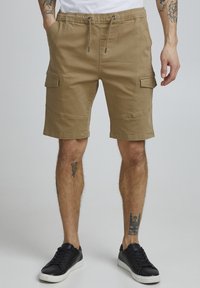 Beige cargoshorts med elastisk midja, snodd och två sidofickor; har sömdetaljer och en avslappnad passform.