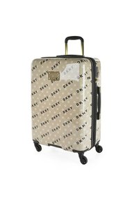 Maleta rígida en beige con patrón del logo negro de DKNY, cuenta con un mango retráctil, cuatro ruedas y un acabado brillante.