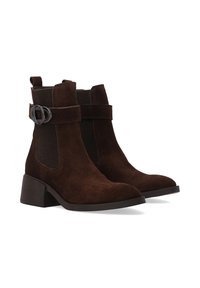 Brązowe zamszowe botki za kostkę z elastycznymi panelami bocznymi, okrągłym noskiem i słupkowym obcasem. Udekorowane ozdobnym paskiem i metalowym zapięciem.