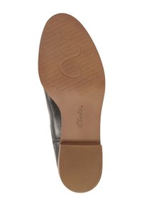 Czarna skórzana podeszwa buta o gładkim wykończeniu, brązowa gumowa podstawa, wzorzysta bieżnia dla lepszej przyczepności oraz wytłoczony logotyp "Clarks".