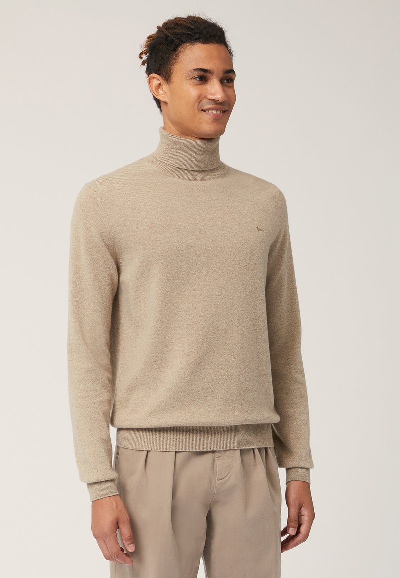 Maglione beige a collo alto in morbido tessuto a maglia, con maniche lunghe e polsini a costine. Piccolo logo sul petto, texture liscia.