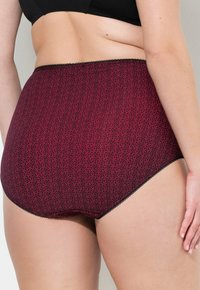 Slip a vita alta in un tessuto rosso scuro con un motivo floreale, caratterizzati da un bordo in pizzo nero lungo il girovita e le aperture delle gambe.