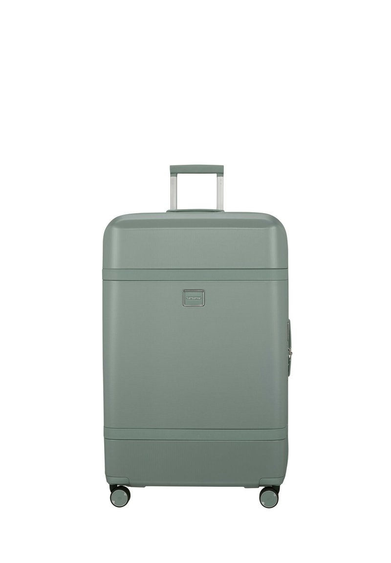 Green hard-shell suitcase with a textured surface, retractable handle, and four wheels for mobility. Features a small logo and zipper closure.