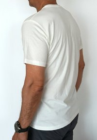 Weißes, kurzärmliges T-Shirt aus weichem Baumwollstoff, mit klassischem Rundhalsausschnitt und lockerer Passform. Keine sichtbaren Muster oder Logos.