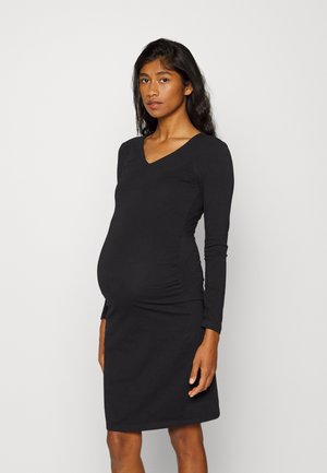 Vestido de maternidade preto de mangas longas com decote em V, forma ajustada e franzidos nas laterais, feito de um tecido elástico e suave.
