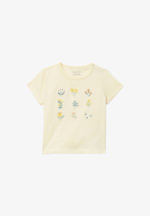 T-shirt crème à manches courtes pour tout-petit avec neuf petites fleurs brodées disposées en trois rangées sur le devant.