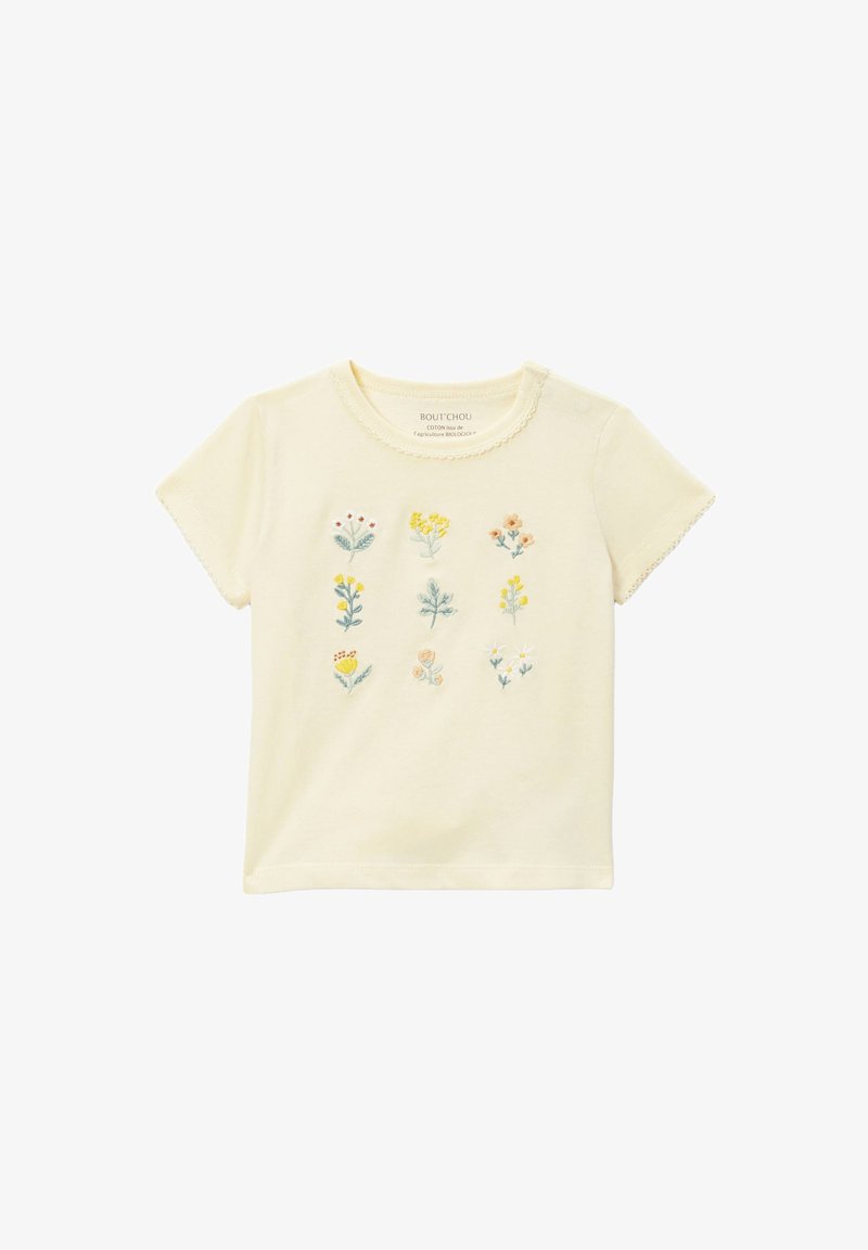 T-shirt crème à manches courtes pour tout-petit avec neuf petites fleurs brodées disposées en trois rangées sur le devant.