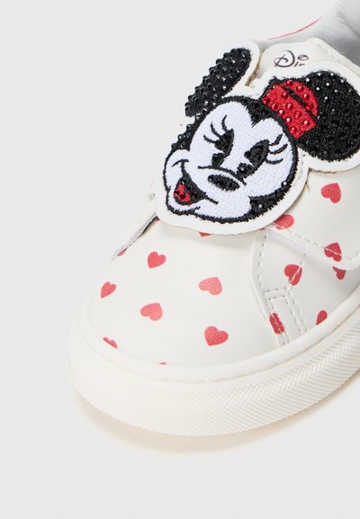 Valge nahast treeningjalats punaste südame mustritega, millel on silmatorkav äsja tikkimisega Minnie's Hiire patch rihmal ja struktureeritud tallal.