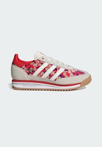 Sneakers med blommönster som har en blandning av röda och vita material, inklusive mocka och textil, med en texturerad sula och tre ränder som logotyp.