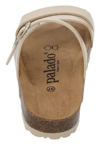 Vit lädersandaler i slidstil med justerbar rem, korkfotbädd och texturerad brun sula. Inuti finns "palado"-logotypen.