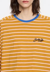 Geel en roze gestreept shirt met lange mouwen, voorzien van een blauwe kraag en een geborduurd logo op de borst. Zachte stof, casual pasvorm.