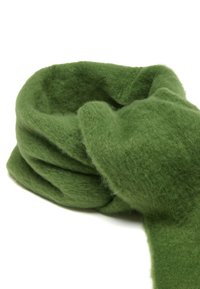 Bufanda de lana verde con un acabado suave y texturizado, que presenta un diseño suelto y doblado. Minimalista, sin patrones visibles ni accesorios.