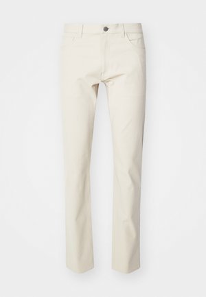 Pantalon en coton beige avec une coupe straight leg, présentant une fermeture à bouton à l'avant, des passants de ceinture et des poches latérales. Texture lisse, look subtil.