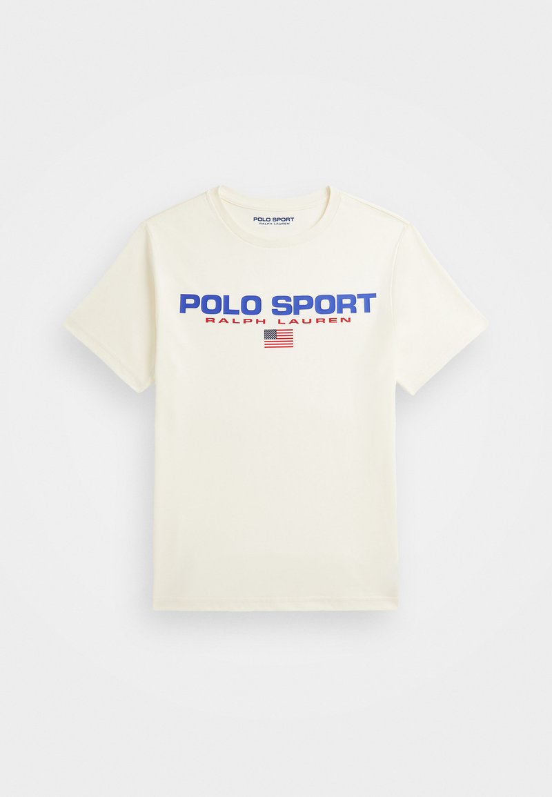 Krema majica s kratkimi rokavi, ki ima v drzni modri barvi napis "POLO SPORT" in "RALPH LAUREN", z majhnim grafičnim prikazom ameriške zastave.