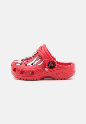 Rød slip-on træsko med justerbar rem, åndbare huller, sølv flamedesign og tekstureret sål for greb og komfort.