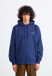 Navy blue hoodie made of cotton with a kangaroo pocket, drawstring hood, and embroidered logo on the chest. Soft texture and relaxed fit.