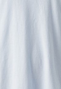 Světle modrá látka s hladkým povrchem, ukazující jemné záhyby a matný vzhled, který naznačuje materiál z bavlny nebo bavlněného směsového materiálu.