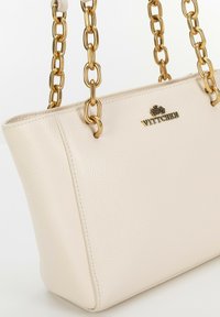 Borsa tote in pelle beige con superficie texture, manici a catena in tonalità oro e logo WITTCHEN impressa sul davanti. Design semplice ed elegante.