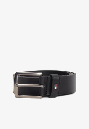 Sort læderbælte med sølv rektangulært spænde og lille rød, hvid og blå rektangulær logo nær spænde løkken.