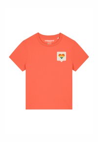 Koraalkleurig katoenen t-shirt met korte mouwen, met een hartvormig regenboogontwerp op een lichte achtergrond in de linkerbovenhoek.