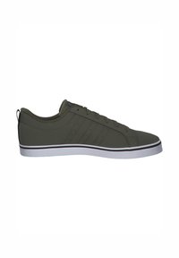 Zapatilla de corte bajo de color verde oscuro con cordones en la parte delantera, tres franjas laterales y suela de goma blanca con finas líneas negras y rojas.