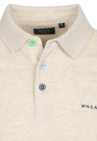 Beige poloshirt met kraag en vier knopen in verschillende kleuren (groen, lichtblauw, donkerblauw) en een merklogo.
