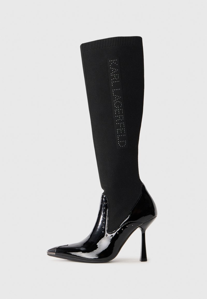 Black knee-high boot featuring a ribbed fabric upper, glossy patent leather toe and heel, pointed shape, and "KARL LAGERFELD" logo detail.
