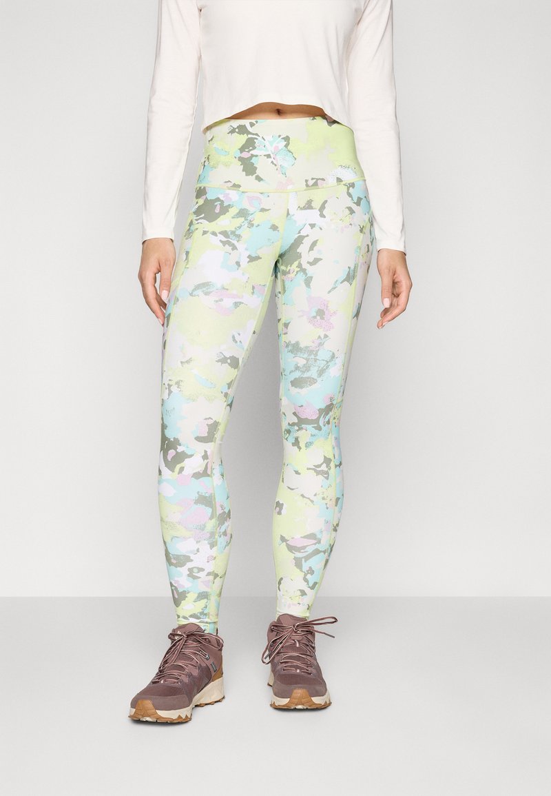 Letvægts, flerfarvede leggings med et camouflage mønster i grønne, blå og pink nuancer, parret med brune vandresko.