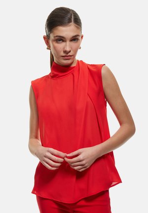 Rotes ärmelloses Oberteil mit hohem Kragen, gefältelten Details und einem fließenden Stoff. Glattes Material und abgerundetem Saum. Keine sichtbaren Verschlüsse.