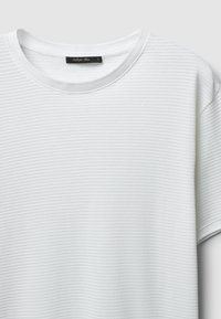T-shirt bianco a maniche corte con un motivo a righe testurizzate, scollatura rotonda e un'etichetta nel colletto con "Callipo Man" e taglia L.